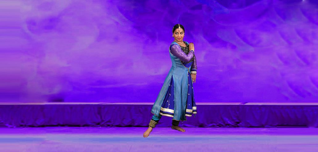 A woman in blue dress standing on stage.