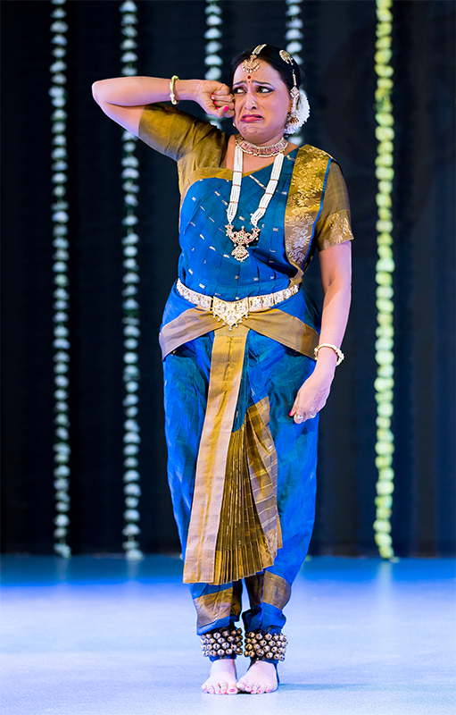A woman in blue and gold dress on stage.