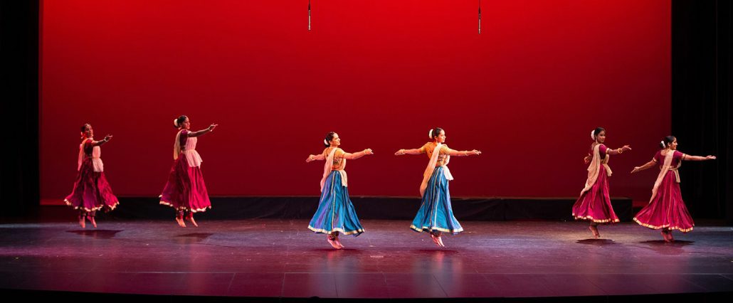 Two dancers in blue dresses on a stage